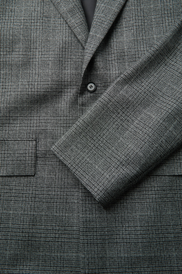 그레이 울 체크 재킷은 남성 고객을 위한 클래식하고 미니멀한 스타일의 아우터입니다. 가을과 겨울에 어울리는 두꺼운 두께감의 울 소재로 제작되었으며, 오버핏 블레이저 디자인에 싱글 버튼 여밈 방식으로 세련된 느낌을 더했습니다. 2mm 어깨 패드와 셋업 라펠 디테일이 특징이며, 체크 패턴이 은은하게 포인트가 됩니다. 오피스룩, 비즈니스 캐주얼, 모임룩 등 다양한 TPO에 적합하며, 시크한 매력을 연출합니다.
