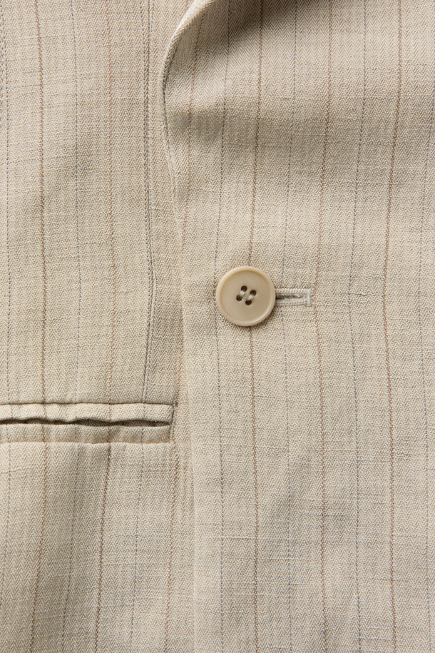 HED MAYNER (헤드 메이너)의 아이보리 린넨 Falling Back 재킷입니다. 부드러운 린넨과 레이온 혼방 소재로 제작되어 봄, 여름 시즌에 적합하며, 릴랙스 핏으로 편안한 착용감을 선사합니다. 와이드 피크드 라펠과 구조적인 어깨 패드가 특징이며, 비대칭 실루엣과 후면 드레이프 디자인으로 모던하고 미니멀한 스타일을 연출합니다. 데이트룩, 오피스룩, 비즈니스 캐주얼 등 다양한 TPO에 시크하게 매치할 수 있는 테일러드 재킷입니다. 안감은 큐프라 비스코스 소재를 사용하여 부드러운 촉감을 더했습니다.
