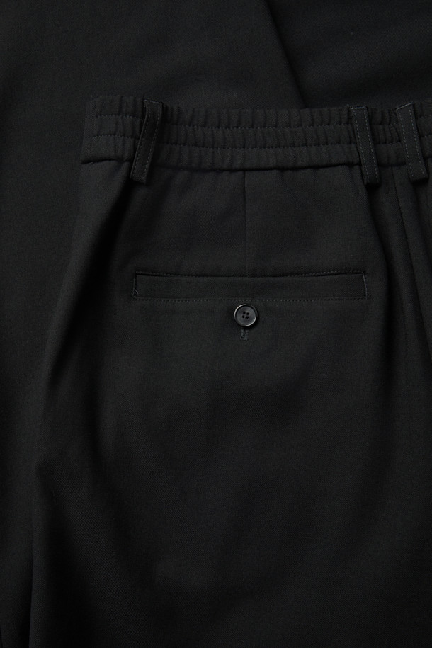 블랙 와이드 핏 팬츠는 남성용 슬랙스로, 일상, 오피스룩, 비즈니스 캐주얼, 모임룩 등 다양한 TPO에 적합합니다. 레이온, 폴리에스테르, 울, 폴리우레탄 혼방 소재로 제작되어 부드러운 촉감을 선사하며, 사계절 내내 착용 가능합니다. 와이드핏에 롱 기장으로, 클래식, 미니멀, 시크 스타일을 연출하기 좋습니다. 허리 부분에 원턱 디테일과 메탈 장식이 더해져 세련된 느낌을 더하며, 하프 밴딩 처리로 편안한 착용감을 제공합니다. 무지 디자인으로 어떤 상의와도 매치하기 용이합니다.
