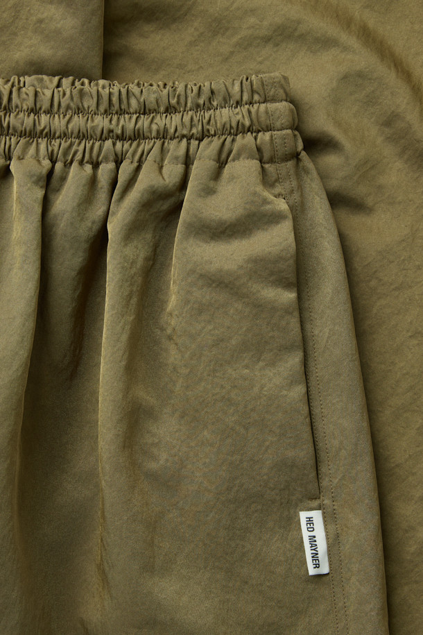 [HED MAYNER] 골드 나일론 유도 팬츠는 이탈리안 나일론 원단으로 제작되어 부드러운 촉감과 은은한 광택감이 돋보입니다. 허리 주름 디테일과 내부 스트링, 포켓 하단의 포인트 라벨이 특징이며, 벌룬핏과 루즈핏으로 편안하면서도 볼륨감 있는 실루엣을 연출합니다. 여행룩, 산책룩 등 다양한 TPO에 활용 가능하며, 미니멀, 캐주얼, 시티보이 스타일을 즐겨 입는 분들께 추천합니다. 무지 디자인으로 어떤 상의와도 매치하기 용이하여 데일리 팬츠로 활용하기 좋습니다.
