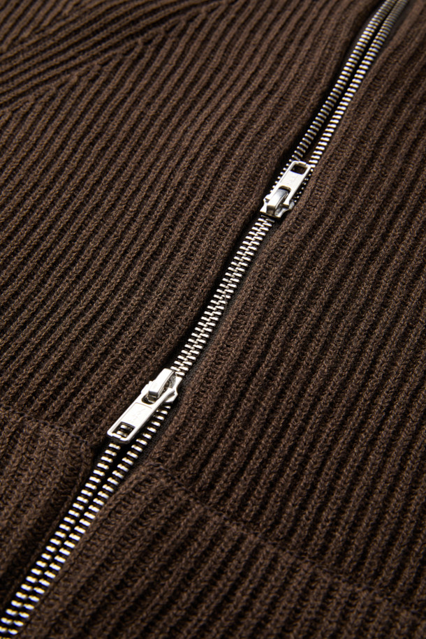 부드러운 촉감의 브라운 터틀넥 집업 베스트입니다. 면 60.2%와 울 39.8% 혼방 소재로 제작되어 간절기에 적합하며, 얇은 두께감으로 편안하게 착용할 수 있습니다. 12GG 골지 패턴으로 베이직한 스타일을 연출하며, 레귤러핏으로 다양한 스타일에 활용할 수 있습니다. 2-Way 지퍼 디테일이 돋보이며, 비즈니스 캐주얼 및 출근룩에 클래식하고 미니멀한 무드를 더해줍니다. 민소매 디자인으로 레이어드하기 좋습니다.
