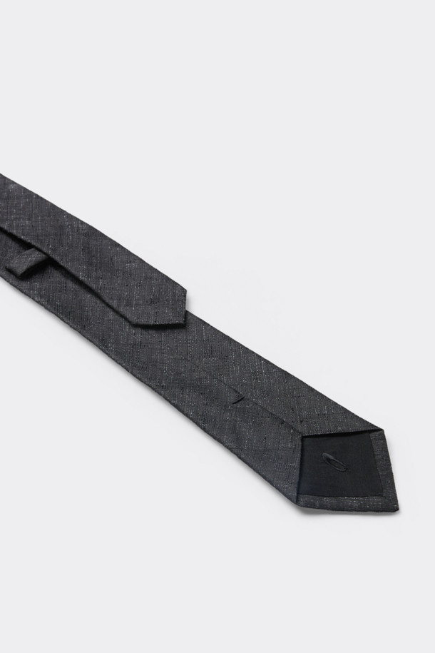 블랙 패턴 넥타이는 실크와 린넨 혼방 원단으로 제작되어 고급스러운 촉감과 견고함을 자랑합니다. 사선과 텍스쳐 무늬가 세련된 디자인을 완성하며, 로고 자수로 포인트를 더했습니다. 이면 루프와 안감, 심지 처리를 통해 넥타이의 형태를 유지하고 내구성을 높였습니다. 오피스룩, 비즈니스 캐주얼, 모임룩 등 다양한 TPO에 활용 가능하며, 클래식, 미니멀, 시크 스타일을 연출하기에 적합합니다. 견 65.1%, 마 34.9%의 소재 혼용률로 제작되었으며, 별도의 패키징으로 제공됩니다.
