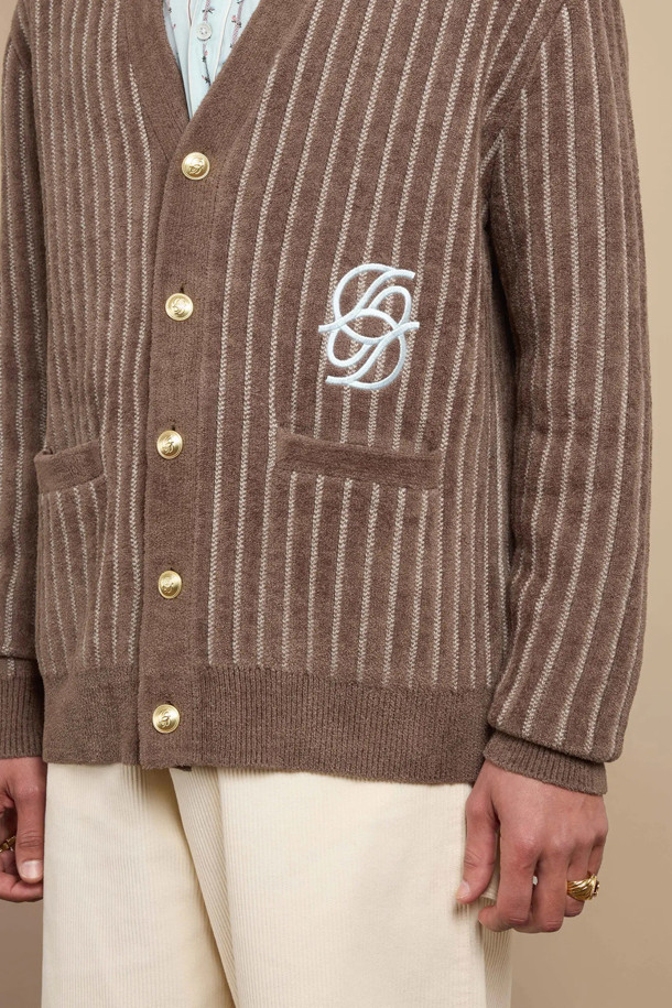 "르 카디건 모노그램"은 가을, 겨울 시즌에 어울리는 클래식 스타일의 상의입니다. 카키 색상의 레귤러 핏 브이넥 가디건으로, 비스코스, 나일론 혼방 소재로 제작되어 부드러운 촉감을 선사합니다. 낮은 암홀 라인과 대비 골지 트림, 5개의 전면 미러 'D' 버튼, 배색 미러 'D' 자수 디테일이 특징입니다. 데이트룩, 모임룩, 미니멀, 시크 스타일을 연출하기에 좋습니다. 긴 소매 기장으로 따뜻함을 더했습니다.
