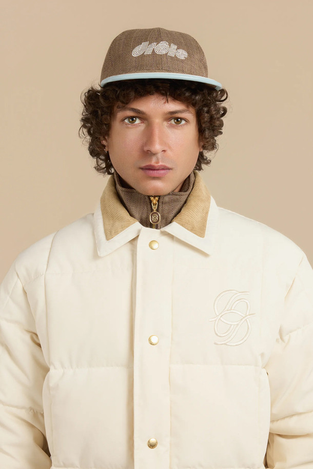 La Doudoune Matelassee (라 두두네 마트라세) 퀼팅 자켓은 가을과 겨울, 일상복으로 활용하기 좋은 아우터입니다. 화이트, 브라운 두 가지 색상으로 출시되었으며, 스포티하고 스트릿한 스타일을 연출할 수 있습니다. 퀼팅 패턴에 크롭 기장, 스냅 여밈, 레귤러핏 디자인이 돋보입니다. 코듀로이 셔츠 칼라와 파이핑 포켓, 배색 립 커프스가 특징이며, 체스트 부분에는 톤온톤 미러드 'D' 자수 디테일이 있습니다. 프리마로프트 충전재를 사용하여 두꺼운 두께감으로 보온성을 높였습니다.
