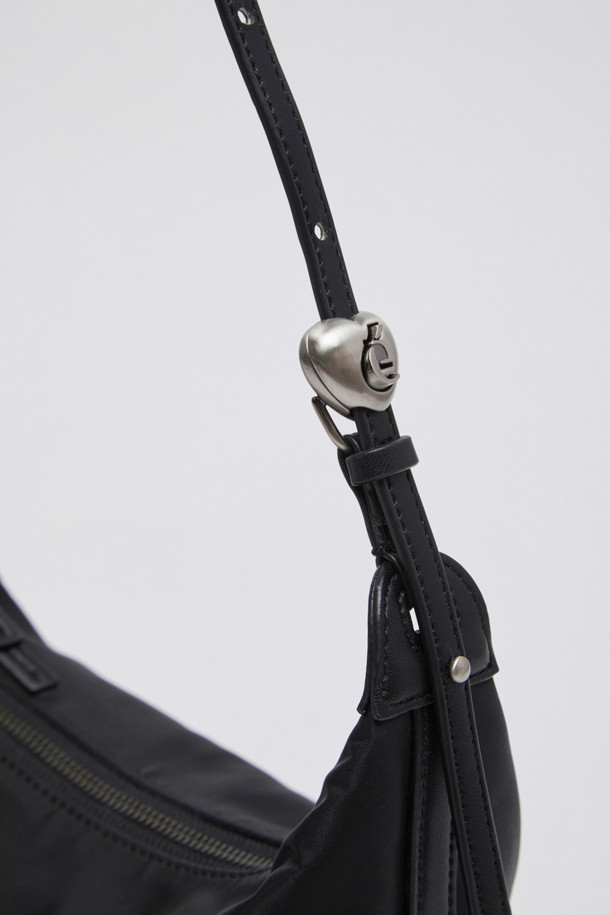 Luv 문 백(Nylon black)은 미니멀, 캐주얼, 클래식 스타일을 즐기는 여성들을 위한 미디엄 사이즈의 호보백입니다. 가볍고 주름이 잘 가지 않는 나일론 소재에 광택감 있는 마감으로 세련됨을 더했으며, 하트 스토퍼와 슬라이더로 길이 조절이 가능한 디자인입니다. 데이트룩, 산책룩, 여행룩 등 다양한 TPO에 활용 가능하며, 지퍼형 잠금 방식으로 내용물을 안전하게 보호합니다. 반원 형태의 무지 디자인으로, 접이식 보관도 가능하며, 더스트 백이 함께 제공됩니다.
