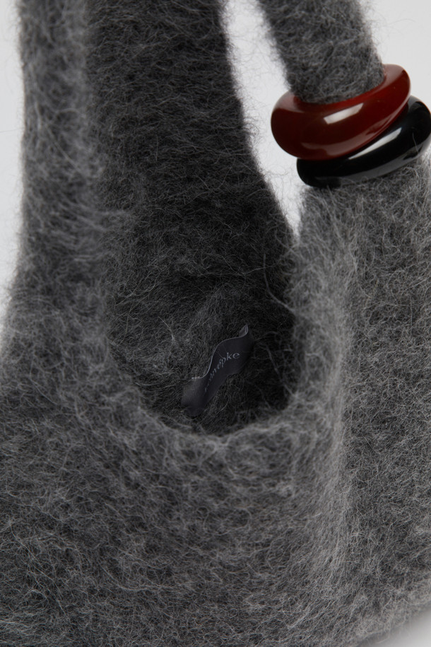 Formica knit bag(Grey)는 부드러운 알파카, 나일론, 스판덱스, 울, 니트 소재로 제작된 여성용 니트백입니다. 미디엄 사이즈의 가방으로, 그레이 색상에 호마이카 장식이 돋보이며, 무지 패턴의 비대칭 및 사각 디자인이 특징입니다. 오픈형 잠금 방식을 갖춘 숄더백 또는 토트백으로, 가볍고 헤어리한 소재감과 유연한 형태가 특징이며 신축성이 있어 편안하게 사용 가능합니다. 데이트룩, 모임룩, 미니멀, 클래식 스타일 연출에 적합합니다.
