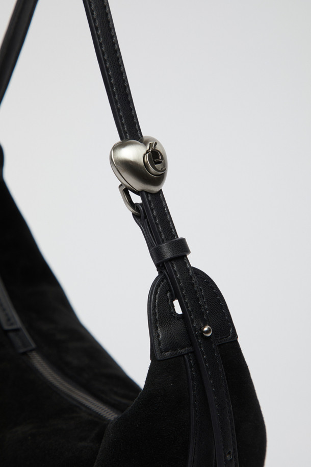 Luv moon bag(스웨이드 블랙)은 부드럽고 매트한 촉감의 스웨이드와 양가죽 소재의 미디엄 사이즈 호보백입니다. 하트 스토퍼 디자인과 반원 모양이 특징이며, 길이 조절이 가능합니다. 블랙 컬러의 무지 디자인으로, 클래식, 미니멀, 시크 스타일을 연출하는 데 적합합니다. 데이트룩, 모임룩, 소개팅룩에 매치하여 세련된 분위기를 더할 수 있습니다. 다만, 털날림과 이염에 취약하며, 물, 땀, 습기에 주의하여 사용해야 합니다.
