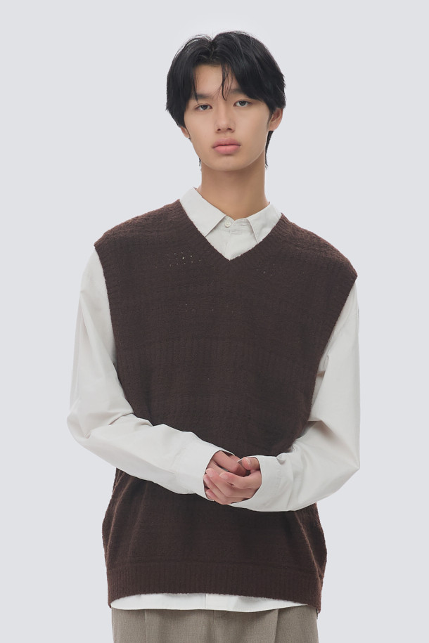 부클 크로쉐 브이넥 니트 베스트는 미니멀하고 베이직한 스타일을 추구하는 남성을 위한 가을, 겨울 필수 아이템입니다. 멜란지 톤의 브라운 컬러에 부드러운 울 소재, 두꺼운 두께감으로 포근함을 선사하며, 여유로운 루즈핏과 크로쉐 무늬가 특징입니다. 브이넥 디자인은 레이어드 스타일링을 용이하게 하며, 구조감 있는 실루엣으로 세련된 룩을 연출합니다. 데이트룩, 모임룩은 물론 겨울 데일리룩까지 폭넓게 활용 가능합니다. 
