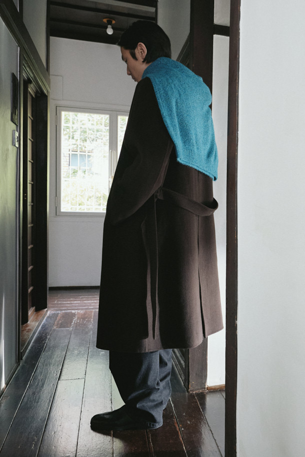 깊이 있는 겨울 스타일을 완성하는 남성용 핸드메이드 벨티드 코트입니다. 브라운 컬러의 울과 캐시미어 혼방 소재로 제작되어 부드러운 촉감과 뛰어난 보온성을 자랑합니다. 발마칸 디자인에 반라글랑 소매, 하프라이닝, A라인 실루엣을 더해 클래식하면서도 미니멀한 감각을 선사합니다. 벨트 디테일로 허리 라인을 강조하여 시크한 무드를 연출하며, 출근룩, 비즈니스 캐주얼, 모임룩 등 다양한 TPO에 활용 가능합니다. 롱 기장에 오버핏으로 제작되어 편안하면서도 세련된 스타일을 완성합니다.
