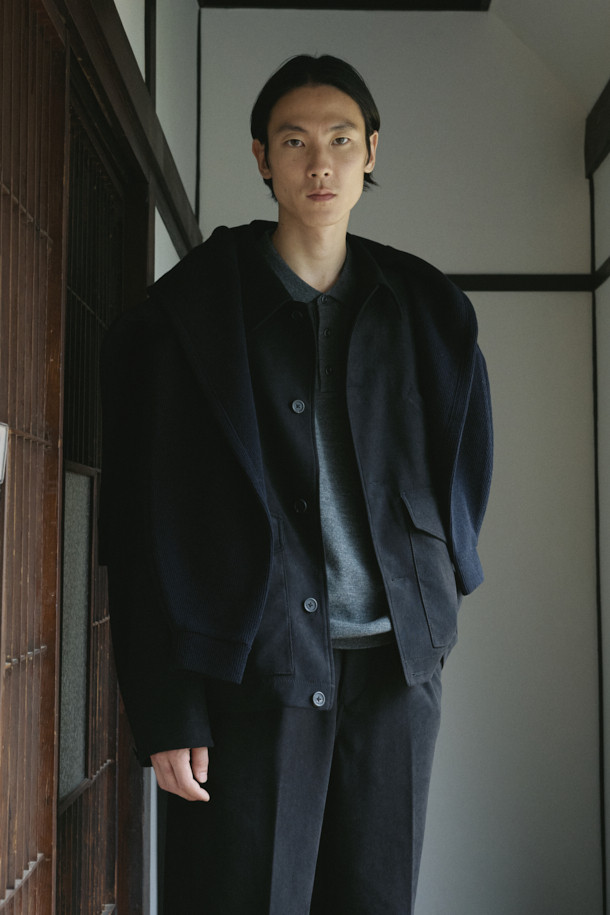 네이비 컬러의 스웨이드 초어 재킷입니다. 부드러운 촉감의 스웨이드 소재로 제작되어 봄, 가을에 착용하기 좋으며, 루즈핏으로 편안한 착용감을 선사합니다. 클래식, 미니멀, 시크 스타일을 연출하기에 적합하며, 데이트룩과 비즈니스 캐주얼에 활용하기 좋습니다. 가슴 사선 주머니, 하단 플랩 포켓, 소매 끝단 버튼, 드로우스트링 등의 디테일이 돋보이는 디자인입니다. 버튼 여밈 방식의 레귤러 기장으로, 다양한 스타일링에 활용할 수 있습니다.
