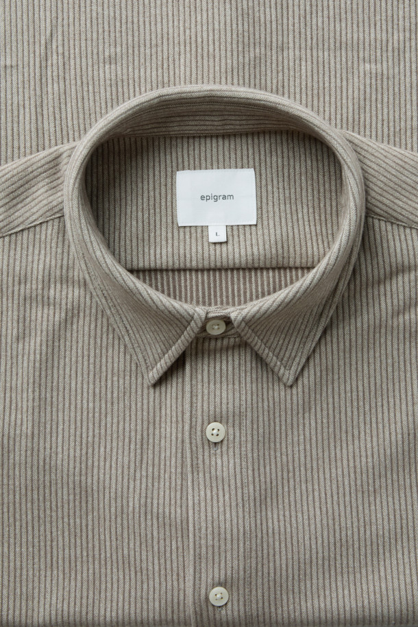 라이트 브라운 컬러의 플란넬 스트라이프 셔츠입니다. 간절기와 초겨울에 어울리는 두꺼운 두께감의 기모 소재로 제작되어 포근한 착용감을 선사합니다. 루즈핏 디자인과 긴 소매 기장으로 캐주얼하고 미니멀한 스타일을 연출하며, 여유로운 실루엣과 도톰한 원단이 특징입니다. 데일리룩, 동네 마실룩, 카페룩 등 다양한 TPO에 활용 가능하며, 시밀러룩 연출에도 용이합니다. 부드러운 텍스처와 스트라이프 패턴이 어우러져 클래식한 분위기를 더합니다.
