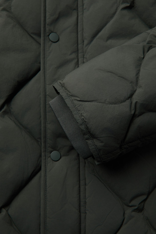 경량 퀼팅 숏 다운 점퍼는 겨울철 따뜻함과 스타일을 모두 잡은 아우터입니다. 세미 오버핏으로 제작되어 편안한 착용감을 선사하며, 드랍 숄더 디자인으로 트렌디한 무드를 연출합니다. 650 필파워의 덕다운 80%, 깃털 20% 충전재에, 숏 기장으로 활동성을 높였습니다. 그린 색상과 퀼팅 패턴이 캐주얼하고 미니멀한 스타일을 완성하며, 캠핑룩과 고프코어 스타일 연출에도 용이합니다. 소매 시보리, 후리스 주머니, 사이드 플랩 포켓, 안쪽 사이드 포켓, 하단 아웃 포켓 등 실용적인 디테일이 돋보이는 제품입니다.
