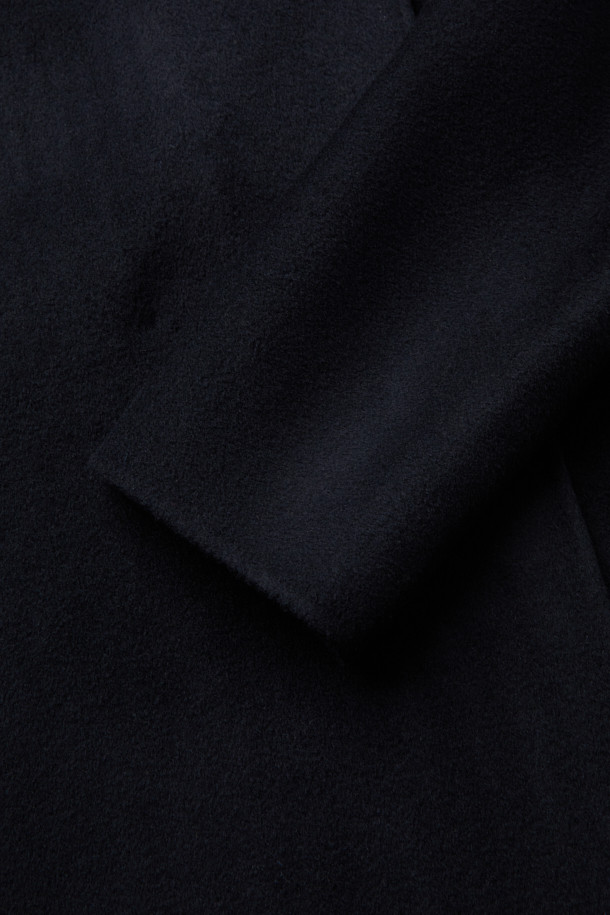 [epigram 여성] 울캐시 블렌드 후드코트는 울과 캐시미어 혼방 소재로 제작되어 부드러운 촉감과 뛰어난 보온성을 자랑합니다. 숄칼라와 후드 디자인이 세련된 멋을 더하며, 데일리룩과 포멀룩 모두 소화 가능한 활용도를 갖췄습니다. 네이비 컬러의 무지 디자인에 더블 버튼 여밈 방식과 루즈핏으로 클래식하면서도 캐주얼한 스타일을 연출합니다. 핸드메이드 봉제와 히든 포켓 디테일로 고급스러움을 더한 하프 기장의 겨울 아우터입니다. 출근룩, 모임룩, 데이트룩 등 다양한 TPO에 맞춰 미니멀하고 클래식한 스타일을 완성해보세요.
