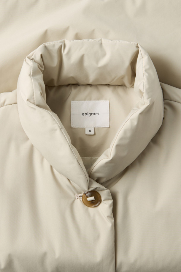 **하이넥 패딩 점퍼(머플러set)**는 겨울철 데일리룩, 동네 마실룩, 산책룩에 어울리는 미니멀하고 베이직한 스타일의 아우터입니다. 아이보리, 화이트 두 가지 색상으로 출시되었으며, 숏 기장의 오버핏 디자인으로 편안한 착용감을 선사합니다. 하이넥 디자인과 머플러 세트 구성으로 보온성을 높였으며, 드롭 숄더, 입체 패턴, 볼륨감, 소매 턱 디테일, 드로우스트링, 아웃포켓 등 다양한 특징을 갖추었습니다. 부드러운 촉감의 폴리에스터 소재로 제작되었으며, 두꺼운 두께감과 경량 패딩 안감으로 따뜻함을 유지해 줍니다. 
