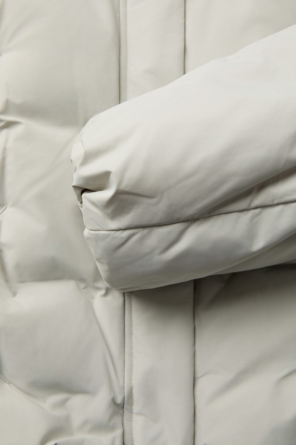 [epigram여성] 후드 스티치 숏 다운은 미니멀한 스타일의 여성용 숏패딩입니다. 하이넥 디자인과 후드가 있어 방풍 및 보온 기능이 뛰어나 겨울철 일상룩과 여행룩에 적합합니다. 덕다운 충전재와 부드러운 촉감으로 편안한 착용감을 선사하며, 오버핏으로 여유로운 실루엣을 연출합니다. 지퍼와 스냅 여밈 방식, 히든 포켓, 소매 엘라스틱 밴딩, 밑단 밴딩, 드로우스트링 등의 디테일이 돋보이며, 화이트 컬러에 무지 패턴으로 다양한 스타일에 매치하기 좋습니다. 
