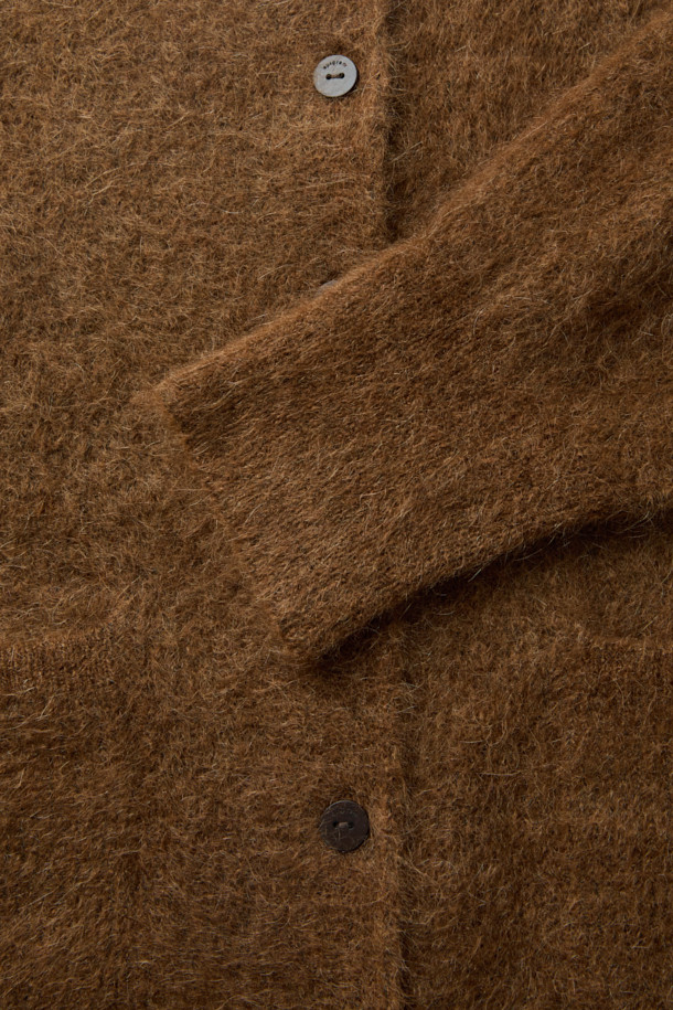 [epigram 여성] 모헤어 라운드 가디건은 부드러운 촉감의 모헤어 69% 함유된 겨울철 필수 아이템입니다. 숏 기장의 루즈핏으로, 미니멀하고 베이직한 스타일을 연출하며, 라운드넥 디자인과 배색 너트 단추로 포인트를 더했습니다. 톤 다운된 브라운 컬러와 무지 패턴은 어떤 옷에도 쉽게 매치되어 데일리룩, 집콕룩, 데이트룩 등 다양한 TPO에 활용할 수 있습니다. 아웃포켓과 립 조직 마감, 세미 드롭 숄더 디테일이 돋보이며, 보온성을 높여 추운 계절에도 따뜻하게 입을 수 있습니다. 
