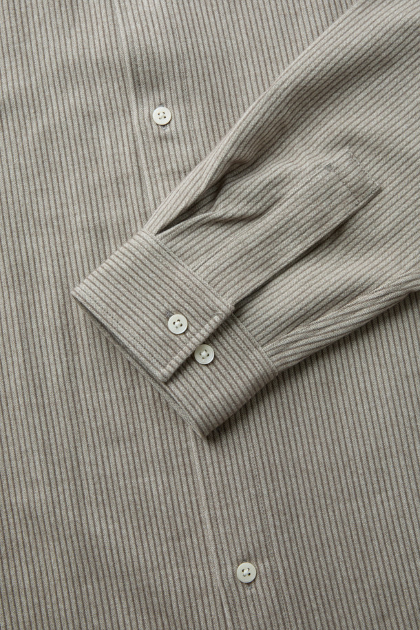 라이트 브라운 컬러의 플란넬 스트라이프 셔츠입니다. 간절기와 초겨울에 어울리는 두꺼운 두께감의 기모 소재로 제작되어 포근한 착용감을 선사합니다. 루즈핏 디자인과 긴 소매 기장으로 캐주얼하고 미니멀한 스타일을 연출하며, 여유로운 실루엣과 도톰한 원단이 특징입니다. 데일리룩, 동네 마실룩, 카페룩 등 다양한 TPO에 활용 가능하며, 시밀러룩 연출에도 용이합니다. 부드러운 텍스처와 스트라이프 패턴이 어우러져 클래식한 분위기를 더합니다.
