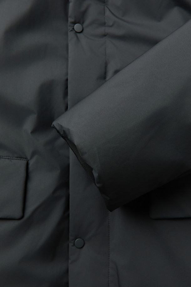 논퀼팅 숏 카라 다운은 미니멀하고 베이직한 스타일의 겨울철 필수 아우터입니다. 블랙 컬러의 무지 디자인으로, 출근룩과 여행룩 등 다양한 TPO에 활용하기 좋습니다. 숏 기장의 레귤러핏으로 제작되었으며, 버튼 여밈 방식과 부드러운 촉감이 특징입니다. 700~750 필파워의 다운 80%, 깃털 20% 충전재에 벨루어 기모 안감, 리브 니트 소매 안감으로 보온성을 높였습니다. 플랩 포켓, 사이드 포켓, 드로우스트링 밑단 등 실용적인 디테일과 방풍, 자외선 차단, 속건, 경량 기능을 갖춘 제품입니다.
