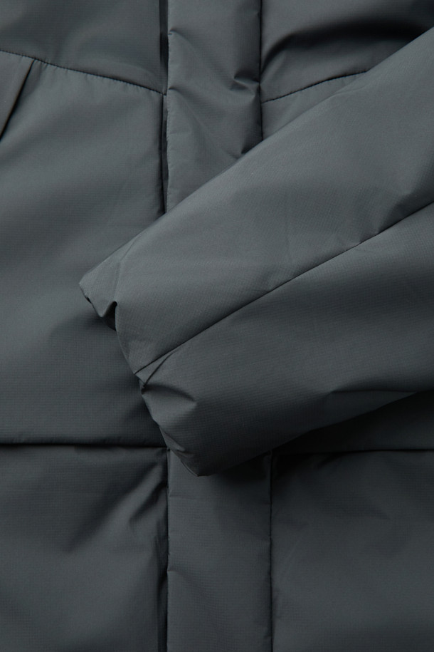 미니멀한 디자인의 논퀼팅 숏 후드 다운입니다. 부드러운 촉감의 폴리에스테르 소재로 제작되어 편안한 착용감을 선사하며, 겨울철 보온을 책임집니다. 80% 다운, 20% 깃털 충전재와 700~750 필파워로 뛰어난 보온성을 제공하며, 방풍 기능으로 외부의 찬 바람을 효과적으로 막아줍니다. TORAY(토레이)사 원단을 사용하여 자외선 차단 및 속건 기능까지 갖췄으며, 오버핏으로 제작되어 편안한 활동성을 보장합니다. 출근룩, 여행룩 등 다양한 TPO에 활용할 수 있으며, 지퍼와 스냅 여밈 방식, 히든 플래킷, 니트 소매 안감, 스트링 밑단 디테일로 완성도를 높였습니다.
