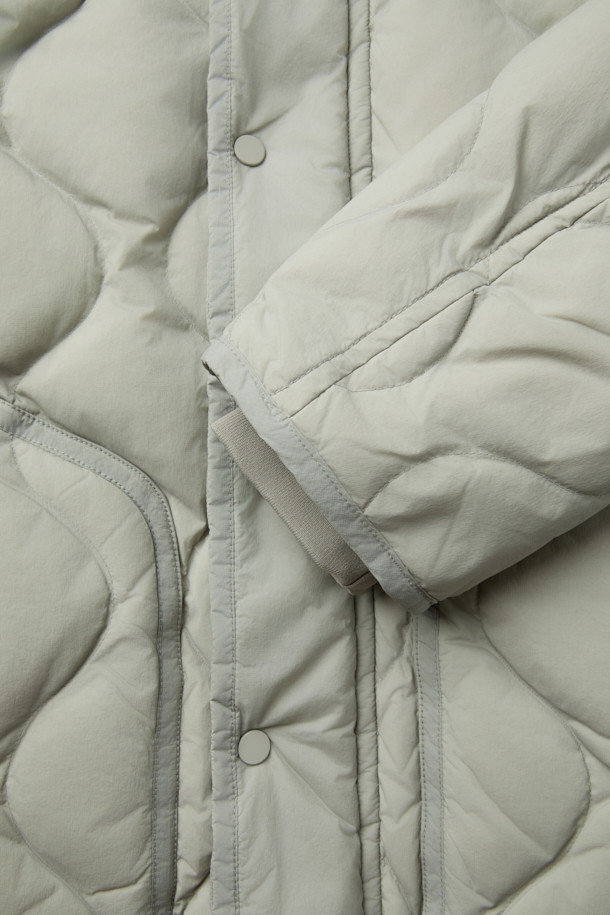 가볍고 따뜻한 경량 퀼팅 후드 다운 점퍼입니다. 겉감은 바스락거리는 나일론 소재, 안감은 부드러운 촉감으로 편안한 착용감을 선사합니다. 머스코비 다운 (솜털 80%, 깃털 20%) 충전재와 700-750 필파워로 뛰어난 보온성을 제공하며, 방풍 기능으로 야외 활동 시에도 쾌적함을 유지해 줍니다. 숏 기장의 루즈핏으로 캐주얼 스타일을 연출하기 좋으며, 후드, 퀼팅, 드로우스트링, 아웃포켓 등의 디테일이 돋보입니다. 여행룩, 캠핑룩, 등산룩 또는 캐주얼, 고프코어, 미니멀 스타일로 다양하게 활용할 수 있습니다.
