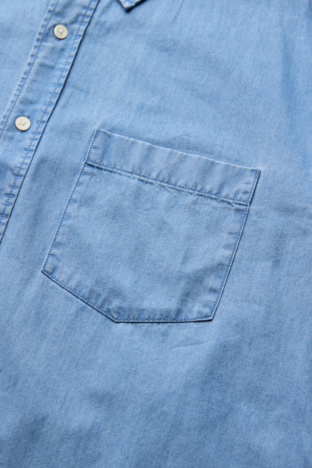 연청 컬러의 데님 코튼 셔츠입니다. 면과 데님 혼방의 NF21사 수입 원단을 사용하여 부드러운 촉감을 선사합니다. 얇은 두께감으로 사계절 내내 활용 가능하며, 차이나 칼라와 세미오버핏으로 캐주얼한 스타일을 연출할 수 있습니다. 드롭 숄더 디자인과 패치 포켓 디테일이 특징이며, 미니멀, 클래식 스타일을 선호하는 분들께 추천합니다. 긴 소매 기장의 무지 셔츠로 다양한 룩에 활용하기 좋습니다.
