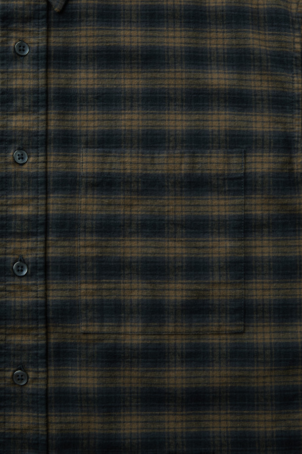 가을과 겨울, 포근함을 선사할 네이비 체크 오버 셔츠입니다. 부드러운 면 소재로 제작되어 편안한 착용감을 자랑하며, 세미 오버핏과 드롭 숄더 디자인으로 캐주얼한 무드를 연출합니다. 네이비와 카키 두 가지 컬러 옵션으로 출시되어, 가을 나들이룩이나 겨울 데일리룩에 활용하기 좋습니다. 체크 패턴이 돋보이는 셔츠는 레이어드하여 다양한 스타일을 시도하기에도 용이합니다. 
