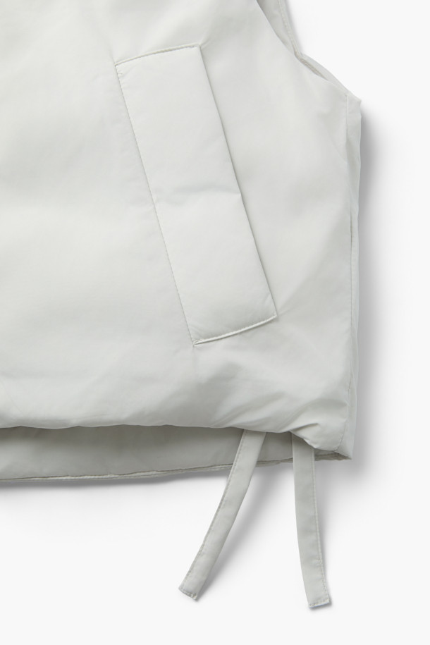 [epigram(에피그램) 여성] 스트링 다운 베스트는 간절기부터 겨울까지 폭넓게 활용 가능한 여성용 베스트입니다. 화이트 컬러의 무지 디자인으로, 캐주얼 및 베이직 스타일을 선호하는 분들께 적합합니다. 세미 오버핏으로 편안하게 착용 가능하며, 덕다운 충전재와 두꺼운 두께감으로 뛰어난 보온성을 제공합니다. 후드, 스트링 디테일, 사이드 포켓, 지퍼형 여밈 방식이 특징이며, 경량 소재로 제작되어 활동성을 높였습니다. 겨울철 데일리룩, 산책룩, 여행룩 등 다양한 TPO에 맞춰 미니멀하고 클래식한 스타일을 연출해보세요.
