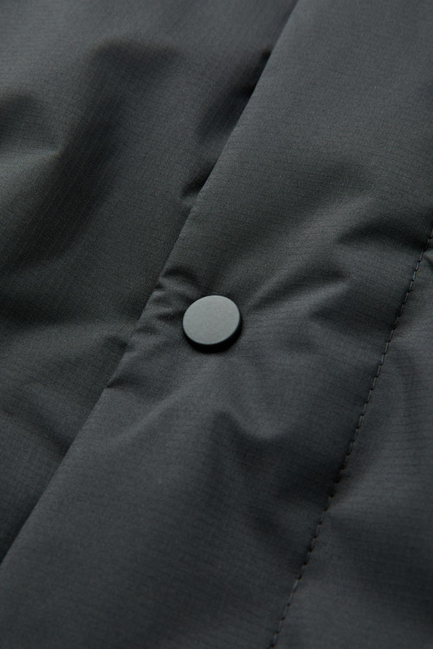 논퀼팅 숏 카라 다운은 미니멀하고 베이직한 스타일의 겨울철 필수 아우터입니다. 블랙 컬러의 무지 디자인으로, 출근룩과 여행룩 등 다양한 TPO에 활용하기 좋습니다. 숏 기장의 레귤러핏으로 제작되었으며, 버튼 여밈 방식과 부드러운 촉감이 특징입니다. 700~750 필파워의 다운 80%, 깃털 20% 충전재에 벨루어 기모 안감, 리브 니트 소매 안감으로 보온성을 높였습니다. 플랩 포켓, 사이드 포켓, 드로우스트링 밑단 등 실용적인 디테일과 방풍, 자외선 차단, 속건, 경량 기능을 갖춘 제품입니다.
