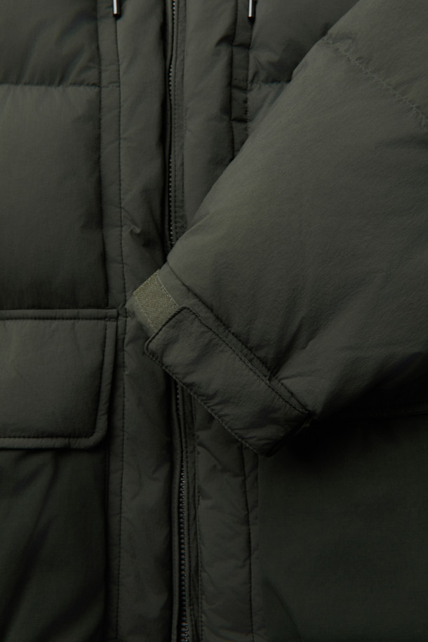 겨울철 캐주얼 스타일을 완성할 퀼팅 후드 미들 다운입니다. 드라이하고 매트한 질감의 나일론 소재로 제작되었으며, 퀼팅 디자인이 돋보입니다. 700~750 필파워의 머스코비 다운(다운 80%, 깃털 20%) 충전재로 보온성을 높였으며, 루즈핏으로 편안하게 착용 가능합니다. 투웨이 지퍼, 드로우스트링, 양옆 투웨이 포켓, 내부 인포켓, 하단 보조 포켓 등 실용적인 디테일을 더했습니다. 출근룩, 여행룩 등 다양한 TPO에 활용 가능하며, 미니멀, 클래식 스타일을 즐겨 입는 분들께 추천합니다.
