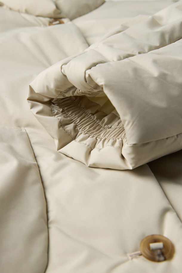 **하이넥 패딩 점퍼(머플러set)**는 겨울철 데일리룩, 동네 마실룩, 산책룩에 어울리는 미니멀하고 베이직한 스타일의 아우터입니다. 아이보리, 화이트 두 가지 색상으로 출시되었으며, 숏 기장의 오버핏 디자인으로 편안한 착용감을 선사합니다. 하이넥 디자인과 머플러 세트 구성으로 보온성을 높였으며, 드롭 숄더, 입체 패턴, 볼륨감, 소매 턱 디테일, 드로우스트링, 아웃포켓 등 다양한 특징을 갖추었습니다. 부드러운 촉감의 폴리에스터 소재로 제작되었으며, 두꺼운 두께감과 경량 패딩 안감으로 따뜻함을 유지해 줍니다. 
