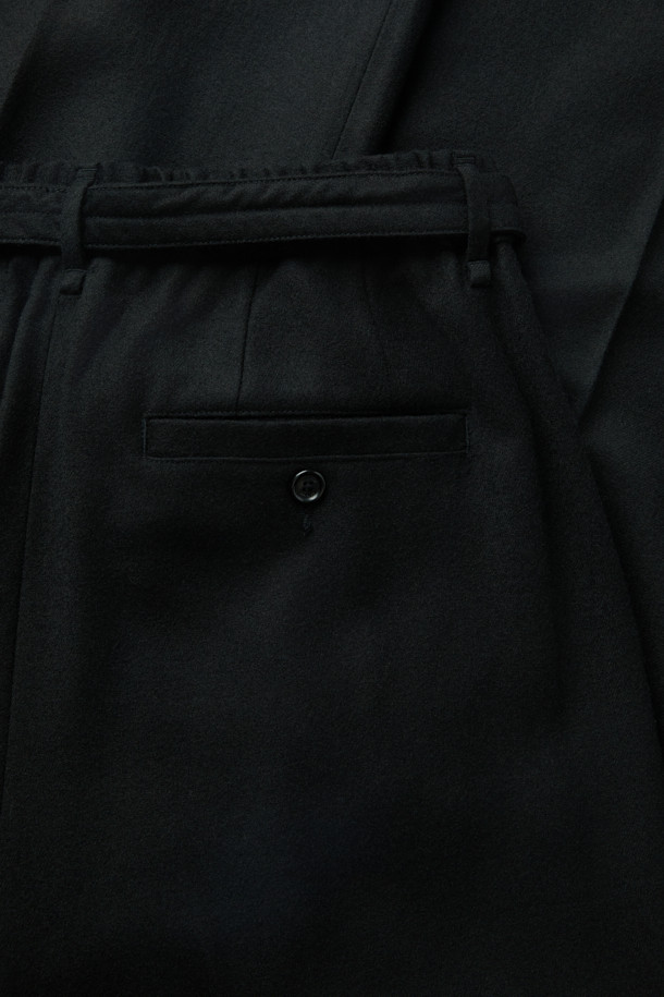 부드러운 울 소재의 블랙 컬러 울 벨트 와이드 팬츠입니다. 탈부착 가능한 벨트와 투턱 디테일이 특징이며, 은은한 광택으로 세련된 무드를 연출합니다. 넉넉한 루즈핏과 두꺼운 두께감으로 겨울철에도 따뜻하게 착용 가능하며, 출근룩, 데일리룩, 오피스룩 등 다양한 TPO에 활용하기 좋습니다. 클래식, 미니멀, 시크 스타일을 즐겨 입는 분들께 추천합니다.
