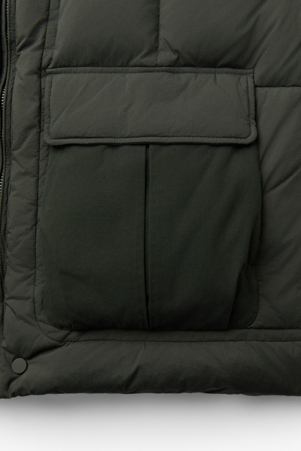 겨울철 캐주얼 스타일을 완성할 퀼팅 후드 미들 다운입니다. 드라이하고 매트한 질감의 나일론 소재로 제작되었으며, 퀼팅 디자인이 돋보입니다. 700~750 필파워의 머스코비 다운(다운 80%, 깃털 20%) 충전재로 보온성을 높였으며, 루즈핏으로 편안하게 착용 가능합니다. 투웨이 지퍼, 드로우스트링, 양옆 투웨이 포켓, 내부 인포켓, 하단 보조 포켓 등 실용적인 디테일을 더했습니다. 출근룩, 여행룩 등 다양한 TPO에 활용 가능하며, 미니멀, 클래식 스타일을 즐겨 입는 분들께 추천합니다.
