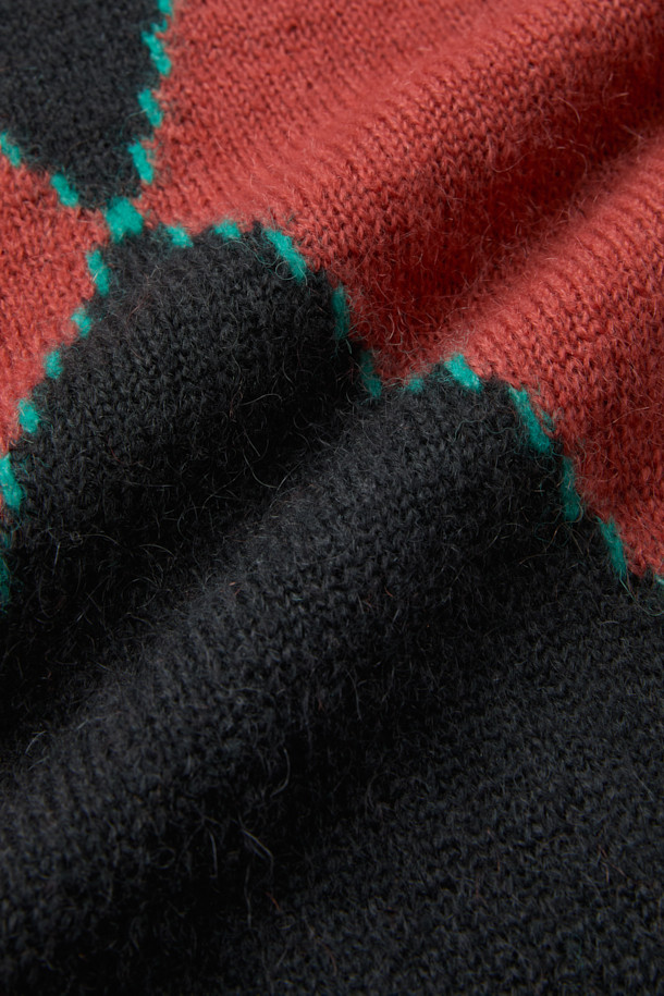 네이비, 브릭, 민트 컬러 배색이 돋보이는 컬러 블럭 아가일 라운드넥 니트 풀오버입니다. 울과 알파카 혼방 소재로 제작되어 포근하고 헤어리한 촉감을 선사하며, 겨울철 따뜻하게 착용하기 좋습니다. 앞뒤 반전 아가일 패턴과 비대칭 컬러 블록 구성이 유니크한 스타일을 연출합니다. 세미 오버핏으로 편안하게 착용 가능하며, 라운드넥과 긴 소매 디자인으로 데이트룩, 클래식, 미니멀, 캐주얼 스타일 모두 소화 가능합니다. 리브 조직 마감과 입체적인 디자인으로 완성도를 높였습니다.
