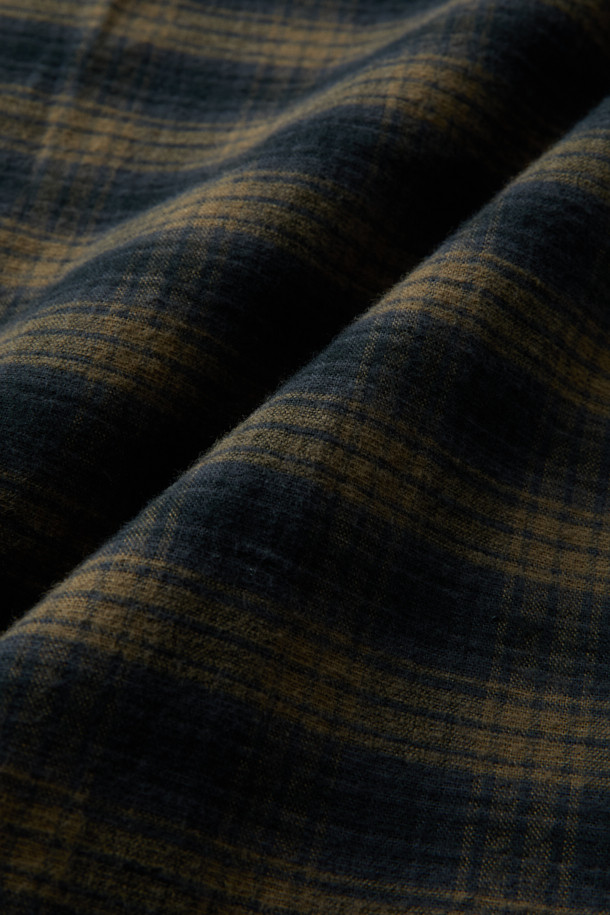 가을과 겨울, 포근함을 선사할 네이비 체크 오버 셔츠입니다. 부드러운 면 소재로 제작되어 편안한 착용감을 자랑하며, 세미 오버핏과 드롭 숄더 디자인으로 캐주얼한 무드를 연출합니다. 네이비와 카키 두 가지 컬러 옵션으로 출시되어, 가을 나들이룩이나 겨울 데일리룩에 활용하기 좋습니다. 체크 패턴이 돋보이는 셔츠는 레이어드하여 다양한 스타일을 시도하기에도 용이합니다. 
