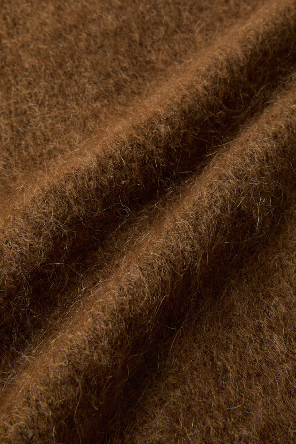 [epigram 여성] 모헤어 라운드 가디건은 부드러운 촉감의 모헤어 69% 함유된 겨울철 필수 아이템입니다. 숏 기장의 루즈핏으로, 미니멀하고 베이직한 스타일을 연출하며, 라운드넥 디자인과 배색 너트 단추로 포인트를 더했습니다. 톤 다운된 브라운 컬러와 무지 패턴은 어떤 옷에도 쉽게 매치되어 데일리룩, 집콕룩, 데이트룩 등 다양한 TPO에 활용할 수 있습니다. 아웃포켓과 립 조직 마감, 세미 드롭 숄더 디테일이 돋보이며, 보온성을 높여 추운 계절에도 따뜻하게 입을 수 있습니다. 
