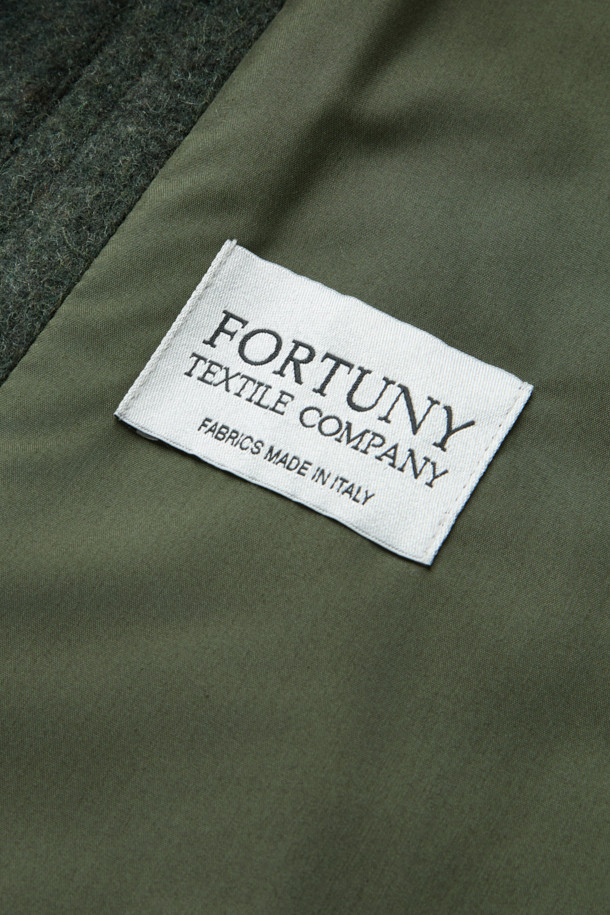 부드러운 헤어리 질감의 울(Wool) 소재로 제작된 다크 카키 컬러의 오버핏 칼라 자켓입니다. 드롭 숄더 실루엣과 소뿔 버튼, 플랩 포켓 디테일이 돋보이며, 이태리 Fortuny사 원단을 사용하여 고급스러움을 더했습니다. 겨울철 일상, 모임, 데이트룩에 코지하면서도 클래식, 미니멀, 캐주얼한 스타일을 연출하기 좋습니다. 두꺼운 두께감으로 따뜻하게 착용 가능하며, 긴 소매 기장으로 안정감을 더했습니다. 초어 재킷 스타일로 다양한 룩에 활용하기 좋은 아이템입니다.
