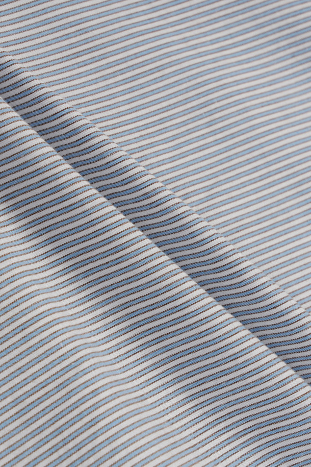 블루와 브라운 컬러의 스트라이프 패턴이 돋보이는 남성용 스트라이프 셔츠입니다. 면 100% 소재로 제작되어 부드러운 촉감을 자랑하며, 사계절 내내 활용 가능한 실용적인 아이템입니다. 클래식과 미니멀 스타일을 동시에 만족시키는 디자인으로, 단정한 어깨선과 오버핏 실루엣이 편안하면서도 세련된 분위기를 연출합니다. 출근룩 및 비즈니스 캐주얼에 적합하며, 이너 또는 단독으로 착용하여 다양한 스타일을 완성할 수 있습니다. 긴 소매 기장의 레귤러 기장으로, 유행을 타지 않는 디자인이 특징입니다.
