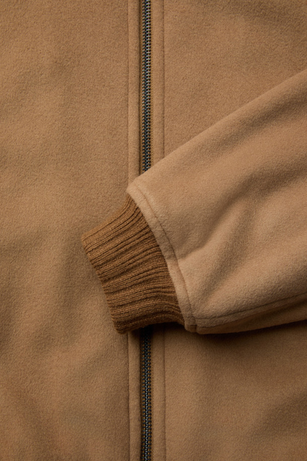 탈부착 퍼 카라 FUR (퍼) 디테쳐블 울 블루종 점퍼는 부드러운 메리노울과 울 소재로 제작되어 겨울철에도 따뜻하게 착용할 수 있습니다. 숏 기장의 볼륨감 있는 핏과 집업 여밈 방식으로 편안함을 더했으며, 클래식과 캐주얼 스타일 모두 소화 가능한 디자인입니다. 퀄팅 안감과 패딩 충전재는 보온성을 높이고, 니트 소매단과 밑단 마감으로 안정적인 착용감을 제공합니다. 은은한 광택감이 매력적인 이 블루종은 탈부착 가능한 퍼 카라로 다양한 스타일을 연출할 수 있습니다.
