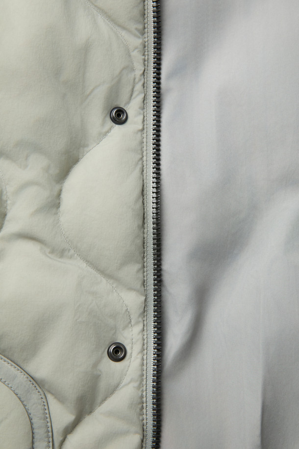 가볍고 따뜻한 경량 퀼팅 후드 다운 점퍼입니다. 겉감은 바스락거리는 나일론 소재, 안감은 부드러운 촉감으로 편안한 착용감을 선사합니다. 머스코비 다운 (솜털 80%, 깃털 20%) 충전재와 700-750 필파워로 뛰어난 보온성을 제공하며, 방풍 기능으로 야외 활동 시에도 쾌적함을 유지해 줍니다. 숏 기장의 루즈핏으로 캐주얼 스타일을 연출하기 좋으며, 후드, 퀼팅, 드로우스트링, 아웃포켓 등의 디테일이 돋보입니다. 여행룩, 캠핑룩, 등산룩 또는 캐주얼, 고프코어, 미니멀 스타일로 다양하게 활용할 수 있습니다.
