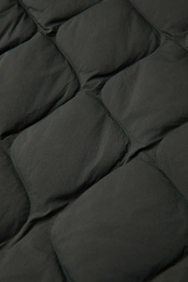 경량 퀼팅 숏 다운 점퍼는 겨울철 따뜻함과 스타일을 모두 잡은 아우터입니다. 세미 오버핏으로 제작되어 편안한 착용감을 선사하며, 드랍 숄더 디자인으로 트렌디한 무드를 연출합니다. 650 필파워의 덕다운 80%, 깃털 20% 충전재에, 숏 기장으로 활동성을 높였습니다. 그린 색상과 퀼팅 패턴이 캐주얼하고 미니멀한 스타일을 완성하며, 캠핑룩과 고프코어 스타일 연출에도 용이합니다. 소매 시보리, 후리스 주머니, 사이드 플랩 포켓, 안쪽 사이드 포켓, 하단 아웃 포켓 등 실용적인 디테일이 돋보이는 제품입니다.
