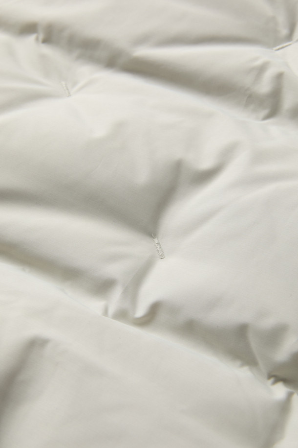 [epigram여성] 후드 스티치 숏 다운은 미니멀한 스타일의 여성용 숏패딩입니다. 하이넥 디자인과 후드가 있어 방풍 및 보온 기능이 뛰어나 겨울철 일상룩과 여행룩에 적합합니다. 덕다운 충전재와 부드러운 촉감으로 편안한 착용감을 선사하며, 오버핏으로 여유로운 실루엣을 연출합니다. 지퍼와 스냅 여밈 방식, 히든 포켓, 소매 엘라스틱 밴딩, 밑단 밴딩, 드로우스트링 등의 디테일이 돋보이며, 화이트 컬러에 무지 패턴으로 다양한 스타일에 매치하기 좋습니다. 
