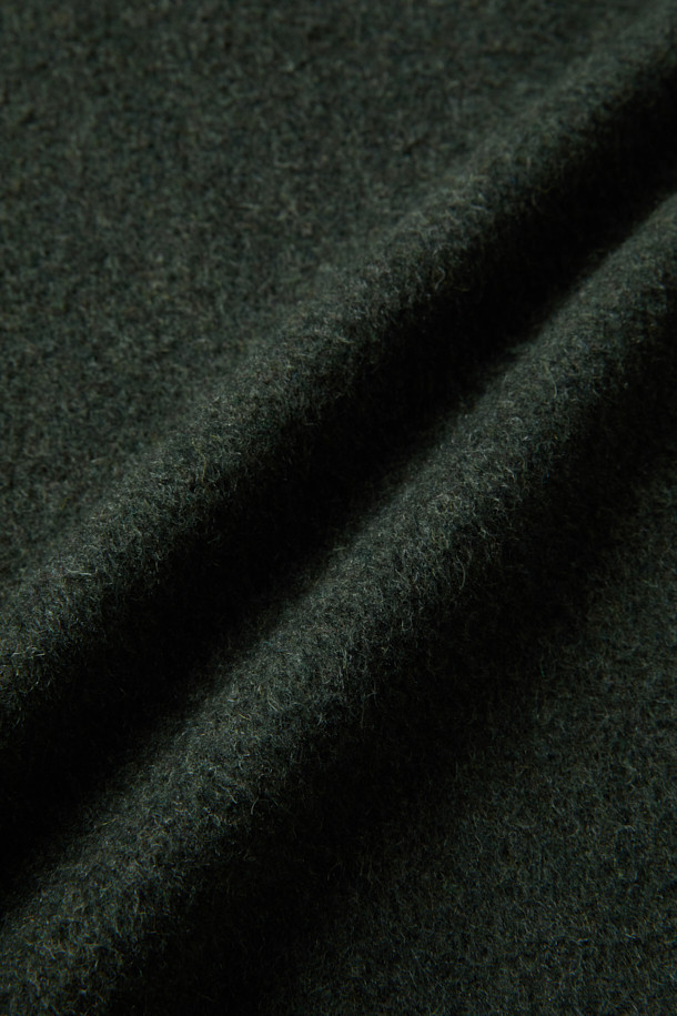 부드러운 헤어리 질감의 울(Wool) 소재로 제작된 다크 카키 컬러의 오버핏 칼라 자켓입니다. 드롭 숄더 실루엣과 소뿔 버튼, 플랩 포켓 디테일이 돋보이며, 이태리 Fortuny사 원단을 사용하여 고급스러움을 더했습니다. 겨울철 일상, 모임, 데이트룩에 코지하면서도 클래식, 미니멀, 캐주얼한 스타일을 연출하기 좋습니다. 두꺼운 두께감으로 따뜻하게 착용 가능하며, 긴 소매 기장으로 안정감을 더했습니다. 초어 재킷 스타일로 다양한 룩에 활용하기 좋은 아이템입니다.
