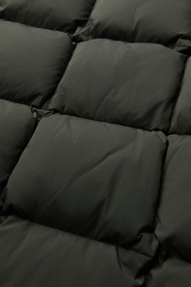 겨울철 캐주얼 스타일을 완성할 퀼팅 후드 미들 다운입니다. 드라이하고 매트한 질감의 나일론 소재로 제작되었으며, 퀼팅 디자인이 돋보입니다. 700~750 필파워의 머스코비 다운(다운 80%, 깃털 20%) 충전재로 보온성을 높였으며, 루즈핏으로 편안하게 착용 가능합니다. 투웨이 지퍼, 드로우스트링, 양옆 투웨이 포켓, 내부 인포켓, 하단 보조 포켓 등 실용적인 디테일을 더했습니다. 출근룩, 여행룩 등 다양한 TPO에 활용 가능하며, 미니멀, 클래식 스타일을 즐겨 입는 분들께 추천합니다.
