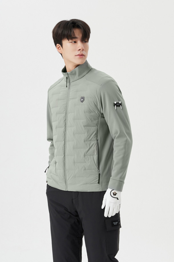 남성용 하이브리드 다운 점퍼입니다. 그레이 컬러의 무지 디자인으로, 가을과 겨울에 골프 또는 일상에서 스포티하고 캐주얼한 스타일을 연출하기 좋습니다. 두꺼운 두께감과 부드러운 촉감의 나일론, 폴리에스테르 혼방 소재로 제작되어 보온성과 방풍 기능을 제공합니다. 레귤러핏에 집업 스타일, 긴 소매 기장으로 활동성을 높였으며, 하이브리드 디자인과 기능성을 더했습니다.
