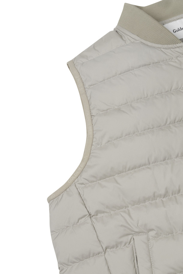 **경량 다운 베스트**

가을, 겨울 시즌에 남성 골퍼 및 일상에서 활용하기 좋은 경량 다운 베스트입니다. 그레이, 베이지, 블랙 3가지 색상으로 출시되어 다양한 스타일에 매치하기 용이합니다. 나일론 소재에 다운 80%, 페더 20% 충전재를 사용하여 보온성을 높였으며, 슬림핏, 데일리핏, 오버핏으로 취향에 맞게 선택할 수 있습니다. 지퍼 여밈 방식에 민소매 디자인으로, 스트레치 밴드 암홀 마감, 세미오토락 지퍼풀러, 사선 싱글월트 포켓, 스트링 밑단 조절, 안티필링 가공 넥밴드, 자수 와펜 등 디테일한 특징을 갖춘 스포티하고 미니멀한 캐주얼 스타일의 아우터입니다.
