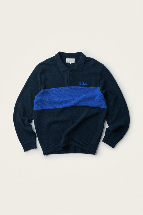 **British Sporting Club 컬러 블록 폴로 니트**

네이비와 블루 컬러 배색이 돋보이는 [British Sporting Club] (브리티시 스포팅 클럽)의 컬러 블록 폴로 니트입니다. 부드러운 촉감의 부클사 니트 소재로 제작되어 가을 시즌에 따뜻하게 착용하기 좋습니다. 루즈핏으로 편안하며, 긴 소매와 폴로넥 디자인이 클래식하면서도 스포티한 무드를 연출합니다. 가슴 부분에는 B.S.C 자수 로고가, 소매와 밑단은 립 조직 마감으로, 단추 여밈 디테일이 돋보입니다. 데이트룩, 카페룩, 가을 나들이룩 등 다양한 스타일링에 활용해 보세요.
