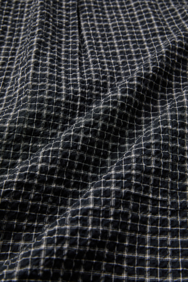 블랙 써커 체크 셔츠 (컴포트핏)는 비즈니스 캐주얼과 일상 모두에 어울리는 셔츠입니다. 시원한 착용감을 선사하는 시어서커 원단과 신축성 있는 소재로 편안한 착용감을 제공합니다. 캐주얼, 클래식, 미니멀 스타일을 모두 소화할 수 있으며, 가을에 적합합니다. 블랙 컬러의 체크 패턴과 긴 소매 디자인이 특징이며, 가슴 포켓과 뒷면 요크 주름 디테일로 포인트를 더했습니다. 가슴둘레는 122CM이며, 컴포트핏으로 제작되었습니다.
