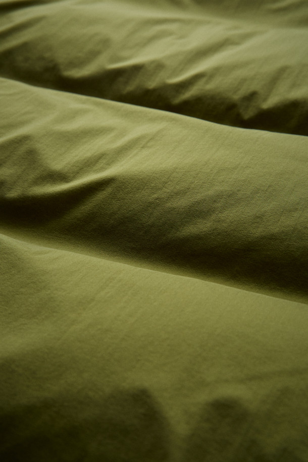 FFC x DOCUMENT (FFC x 도큐먼트) 피셔맨 셔팅 구스 다운 재킷은 겨울철 데일리룩에 적합한 미니멀하면서도 캐주얼한 스타일의 아우터입니다. 올리브 및 카키 색상으로 출시되었으며, 가볍고 따뜻한 구스다운 90/10 충전재를 사용하여 보온성과 경량성을 동시에 잡았습니다. 셔츠형 디자인에 투웨이 지퍼 여밈 방식과 입체 포켓 디테일을 더해 실용성을 높였으며, 여유 있는 어깨 라인과 루즈핏으로 편안한 착용감을 선사합니다. 부드러운 촉감의 나일론 소재로 제작되었으며, 긴 소매 기장과 두꺼운 두께감으로 추운 겨울에도 따뜻하게 입을 수 있습니다.
