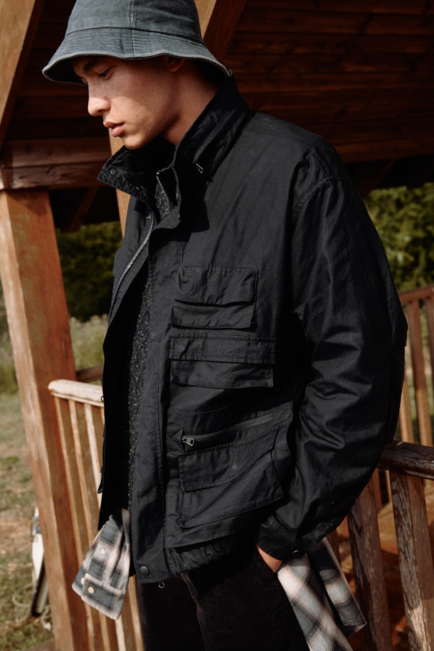 [Fly Fishing Club] 피셔맨 재킷 (왁스 코튼)은 헤리티지 감성과 빈티지 무드를 자아내는 아우터입니다. 왁스 코튼 소재로 제작되어 방수, 통기, 내구성이 뛰어나 가을철 나들이룩과 여행룩에 적합합니다. 블랙 컬러의 루즈핏 디자인으로, 멀티 포켓, 숨겨진 후드, YKK 지퍼, 립스탑 원단 등의 다양한 특징을 갖추었습니다. YKK 지퍼와 스냅 버튼으로 여밈이 가능하며, 긴소매 디자인으로 클래식, 워크웨어, 캐주얼 스타일 모두 소화 가능합니다. 내피 연결 스냅이 있어 실용성을 높였습니다.
