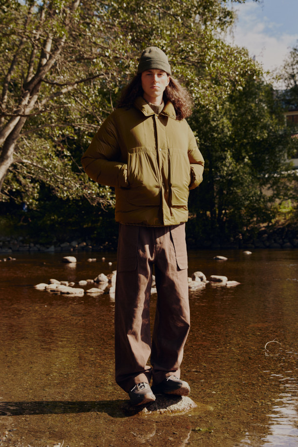 FFC x DOCUMENT (FFC x 도큐먼트) 피셔맨 셔팅 구스 다운 재킷은 겨울철 데일리룩에 적합한 미니멀하면서도 캐주얼한 스타일의 아우터입니다. 올리브 및 카키 색상으로 출시되었으며, 가볍고 따뜻한 구스다운 90/10 충전재를 사용하여 보온성과 경량성을 동시에 잡았습니다. 셔츠형 디자인에 투웨이 지퍼 여밈 방식과 입체 포켓 디테일을 더해 실용성을 높였으며, 여유 있는 어깨 라인과 루즈핏으로 편안한 착용감을 선사합니다. 부드러운 촉감의 나일론 소재로 제작되었으며, 긴 소매 기장과 두꺼운 두께감으로 추운 겨울에도 따뜻하게 입을 수 있습니다.
